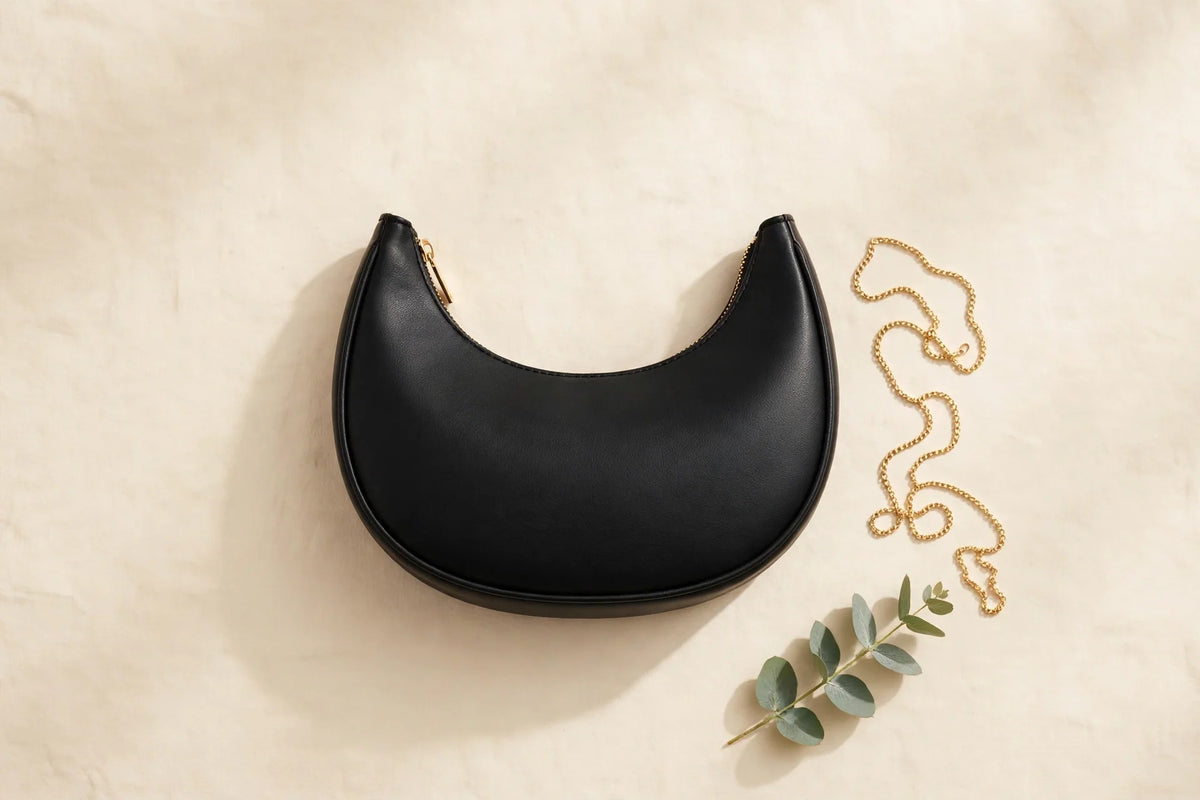 Black crescent shoulder bag on a cream background, the Moon Black Crescent Bag at Rs 999